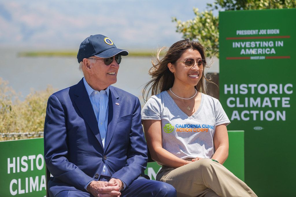 President Joe Biden and environmental student Chiena Ty, sitting outside wile wearing sunglasses.